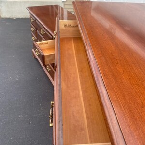 Puede incluir: Un primer plano de un caj&oacute;n de c&oacute;moda de madera con una manija de lat&oacute;n. El caj&oacute;n est&aacute; abierto y el interior es visible. El caj&oacute;n est&aacute; etiquetado con "Thomasville" en el interior.