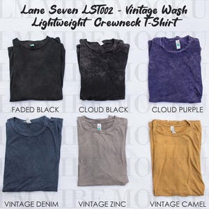 May include: Six vintage wash, lightweight crewneck t-shirts are displayed in a range of colours. The colours include faded black, cloud black, cloud purple, vintage denim, vintage zinc, and vintage camel. The text "Lane Seven LST002" and "Lightweight Crewneck T-Shirt" is visible.