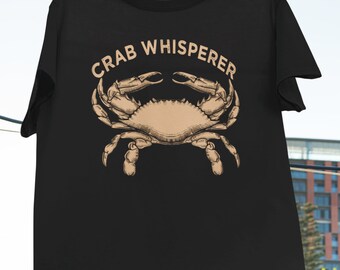 May include: Black t-shirt with the text "CRAB WHISPERER" in white lettering and a brown illustration of a crab.