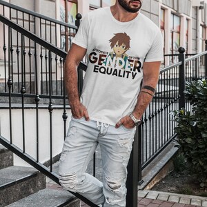 May include: A white t-shirt featuring a cartoon character and the text "Advocate of True Gender Equality". The person wearing the shirt is standing on a set of stairs.