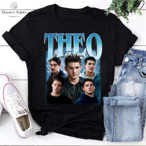 Pode incluir: Camiseta preta com um gráfico de cinco homens, o nome "THEO" em letras azuis grandes e o nome "Parker" em letras menores. O design tem uma estética vintage com um padrão de raio atrás dos nomes e imagens.