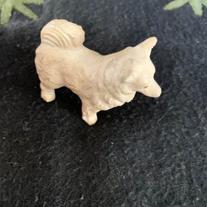 Miniature Pomeranian dog collectible. A small white LINEOL dog figurine with a fluffy tail. The dog is standing on all four legs and has its head tilted to the side.