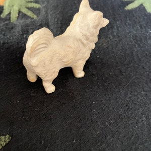 LINEOL toy dog side view. A white LINEOL dog figurine with a fluffy tail and a standing pose.