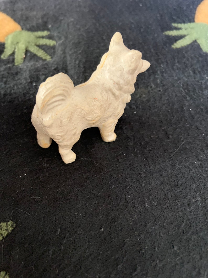 LINEOL toy dog side view. A white LINEOL dog figurine with a fluffy tail and a standing pose.