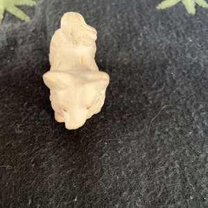 LINEOL animal figurine 2 inch. A small white LINEOL figurine of a dog sitting on its hind legs with its head tilted down. The dog has a long tail that curls up over its back.