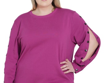 May include: A long-sleeved magenta sweatshirt with black button accents on the sleeves. The sweatshirt has a relaxed fit and a round neckline.