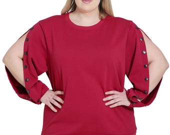 May include: A maroon long-sleeved sweatshirt with a round neckline and button detailing on the sleeves. The sweatshirt has a relaxed fit and is made of a soft, comfortable fabric.