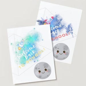 May include: Two white cards with a space theme. One card has a rocket ship and the words "Welcome Back To School!" The other card has a rocket ship and the words "Come Back To School!" Both cards have a smiling moon.