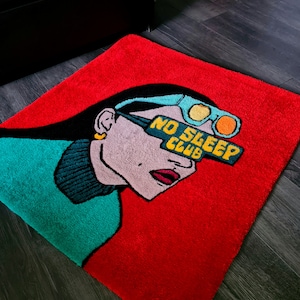 Puede incluir: Alfombra roja con una ilustración de dibujos animados de una mujer con gafas de sol con el texto "NO SLEEP CLUB" en las gafas de sol.