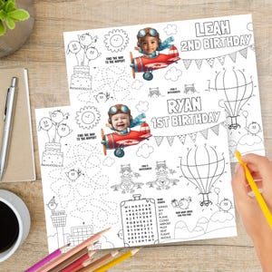 May include: Two coloring pages with aviation-themed illustrations. One page is labeled "Leah 2nd Birthday" and the other "Ryan 1st Birthday". Each page has a maze, word search, and images of airplanes, hot air balloons, and birds.