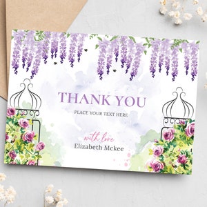 May include: Thank you card with a watercolor design of purple wisteria flowers and pink roses. The card has a black metal gate with a floral design and the text "Thank You" with the words "Place your text here" below. The card also has the text "with love Elizabeth McKee".