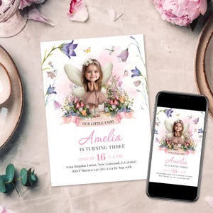 Op de afbeelding: Een gedrukte uitnodiging en een smartphone met hetzelfde ontwerp. De uitnodiging toont een aquarel illustratie van een feeënmeisje met vleugels, omringd door bloemen. De tekst luidt "Amelia wordt drie."