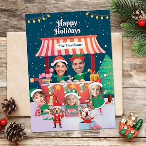 Könnte beinhalten: Eine personalisierte Weihnachtskarte mit dem Text "Happy Holidays" und "The Davidsons". Die Karte zeigt eine Familie und Hunde mit ihren Gesichtern auf Cartoon-Charakteren in einer festlichen Szene mit einem Weihnachtsbaum.
