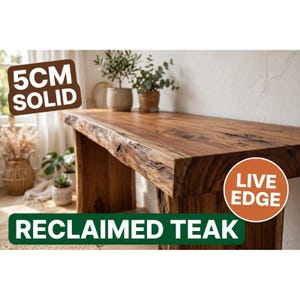 Peut inclure: Une console en bois de teck massif recyclé avec un design à bord naturel. Le plateau de la table a une épaisseur de 5 cm. Le bois présente un grain brun riche avec des nœuds visibles et un profil de bord organique texturé, soutenu par des pieds en bois.