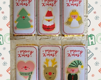 May include: Six chocolate bars with festive Christmas-themed wrappers. Each wrapper features a different cartoon character, including a Christmas tree, Santa Claus, an angel, a heart, a reindeer, and an elf. The words "Merry X'mas" are printed on each wrapper.