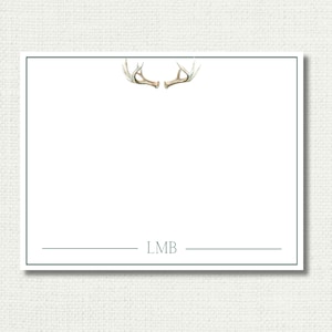 May include: A white card with a green border and a pair of antlers at the top. The card has a line at the bottom with the text "LMB" printed on it.