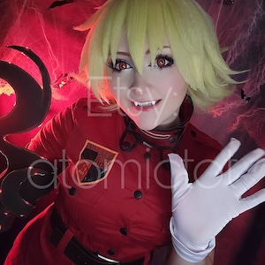 Könnte beinhalten: Eine Frau in einer roten Uniform mit einem schwarzen Gürtel und einem schwarzen und goldenen Aufnäher mit der Aufschrift "HELLSING". Sie trägt weiße Handschuhe und hat blondes Haar und rote Augen. Sie lächelt und zeigt ihre Zähne. Der Hintergrund ist dunkel und hat einen roten Schein.