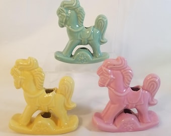 Juego de candelabros vintage de cerámica esmaltada en forma de caballo balancín de color rosa, verde y amarillo