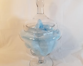May include: A clear glass cloche with a round base and a domed lid. The cloche is filled with light blue tissue paper.