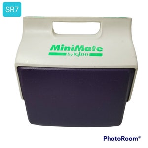 Puede incluir: Una nevera MiniMate blanca y morada de Igloo. La nevera tiene un logotipo verde que dice "MiniMate by Igloo".
