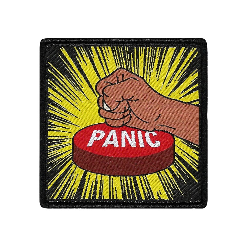 Pode incluir: Um remendo de estilo de banda desenhada preto e amarelo com uma m&atilde;o a pressionar um bot&atilde;o vermelho que diz "PANIC" em letras brancas.