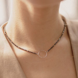 Our silver circle necklace can be seen on the woman neck, who wears it delicately on her skin.