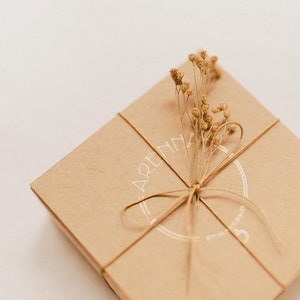 Our recycled cardboard box that we use for packaging, totally sustainable, with our brand logo in gold. It is also decorated with tiny dried flowers.