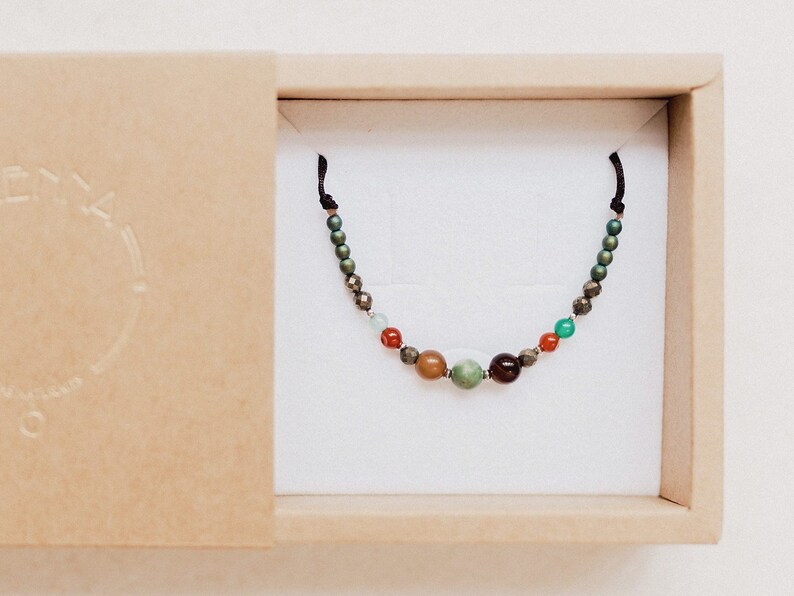 The boho chic gemstone bracelet is seen inside its cardboard box, ready to present as a boho, bohemian and colorful gift for her.