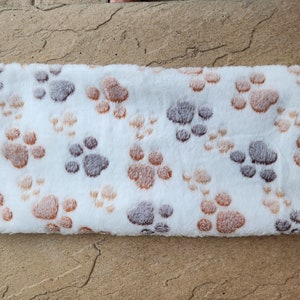 May include: White plush blanket with a brown and gray paw print pattern.