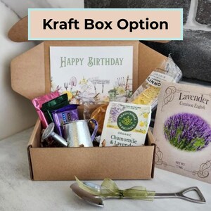 May include: A kraft box labeled "Kraft Box Option" contains a birthday card, tea packets, a small watering can, and a packet of lavender seeds. A small shovel-shaped bottle opener rests in front of the box. The card reads "Happy Birthday."