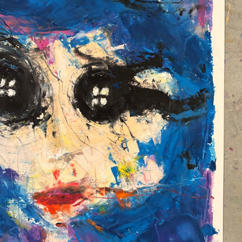 May include: Abstract painting of a face with button eyes and red lips. The artwork features thick brushstrokes in shades of blue, yellow, and white, creating a textured appearance. The eyes are large, black buttons with white stitching.