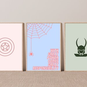 K&ouml;nnte beinhalten: Drei gerahmte Drucke mit Superhelden-Motiven. Der linke Druck hat einen rosa Hintergrund mit einer roten Umrandung von Captain Americas Schild. Der mittlere Druck hat einen hellblauen Hintergrund mit einem roten Spinnennetz und dem Text "With great power comes great responsibility". Der rechte Druck hat einen hellgr&uuml;nen Hintergrund mit einer dunkelgr&uuml;nen Silhouette von Loki.