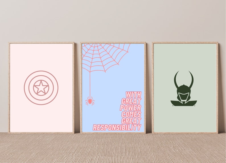 K&ouml;nnte beinhalten: Drei gerahmte Drucke mit Superhelden-Motiven. Der linke Druck hat einen rosa Hintergrund mit einer roten Umrandung von Captain Americas Schild. Der mittlere Druck hat einen hellblauen Hintergrund mit einem roten Spinnennetz und dem Text "With great power comes great responsibility". Der rechte Druck hat einen hellgr&uuml;nen Hintergrund mit einer dunkelgr&uuml;nen Silhouette von Loki.