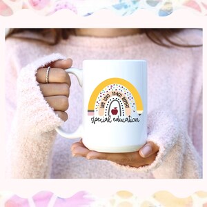 May include: White ceramic mug with a yellow rainbow design and the text "Live Love Teach Repeat Special Education".