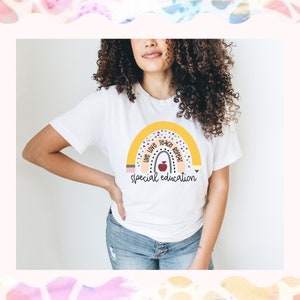 May include: A white t-shirt with a rainbow design and the text "Live Love Teach Repeat Special Education".