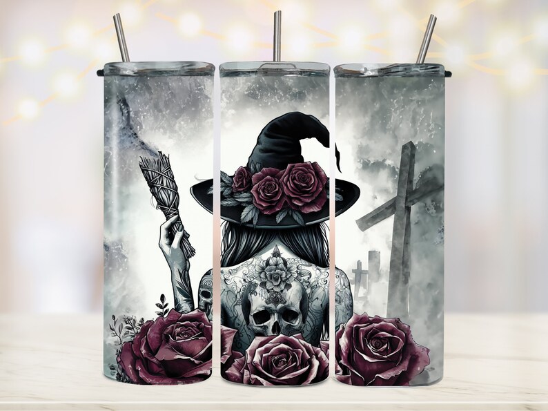 May include: A set of three stainless steel tumblers with a witch, roses, and a graveyard scene. The witch is wearing a black hat with roses on it and has a skull tattoo on her back. The tumblers are perfect for Halloween or any witchy occasion.