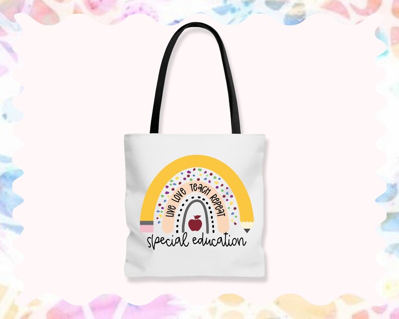 May include: White tote bag with a rainbow design and the text "Live Love Teach Repeat Special Education". The rainbow is yellow with multi-colored dots and a red apple in the center.
