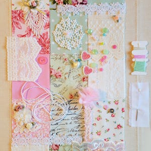 May include: A patchwork of fabric squares in pink, white, and green, adorned with lace, floral patterns, beads, and buttons. Includes a white doily, spools of thread, and a needle with thread.