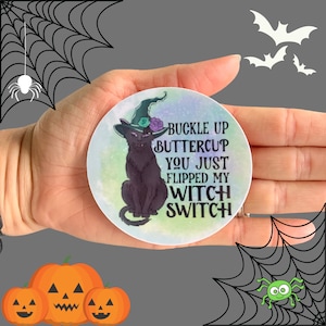 May include: A round sticker with a black cat wearing a witch's hat and the text "Buckle up Buttercup You just flipped my witch switch".