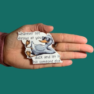 May include: A white sticker with a cartoon duck wearing sunglasses and the text "Whatever life throws at you duck and let it hit someone else..."