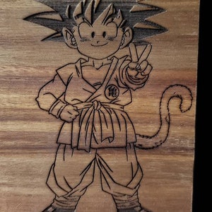 May include: A wooden plaque with a laser-engraved image of a cartoon character with spiky hair, a peace sign, and a tail. The character is wearing a martial arts uniform with a symbol on the chest.