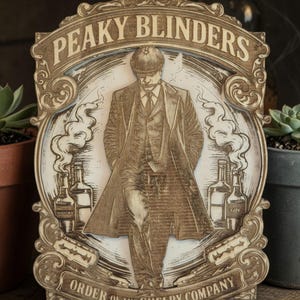 May include: Wooden sign featuring a detailed illustration of a man in a suit and cap, with the text "PEAKY BLINDERS" and "ORDER OF THE SHELBY COMPANY". The sign has a vintage aesthetic with decorative borders and images of whiskey and gin bottles.