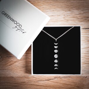 Moon phase necklace presented in white laminated gift box branded with the Greenwood Gifted shop name. Necklace site on black foam within the box ready for gifting.