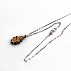 Oak leaf necklace on a white background. The oak leaf pendant is made from oak wood. The chain is silver with a lobster clasp and large end ring for easy fastening.