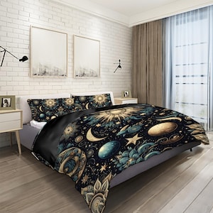 May include: A black duvet cover with a celestial print featuring a sun, moon, stars, and planets in gold and blue tones. The duvet cover is on a bed with two matching pillowcases.