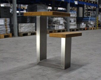 Könnte beinhalten: Ein moderner zweistufiger Beistelltisch mit rechteckiger Holzplatte und gebürstetem Metallsockel. Der Tisch hat ein minimalistisches Design, das für verschiedene Einrichtungsstile geeignet ist. Die Platte ist ca. 45 cm lang.