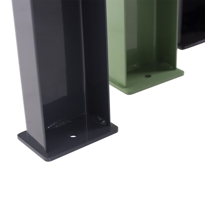 May include: Close-up of the base of three metal legs, one black, one green, and one black. The legs are square and have a flat base with a small hole in the center.