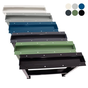 May include: A set of six metal workbenches in various colors, including white, gray, blue, dark gray, green, and black. Each workbench has a metal top with a built-in tray and a metal frame with two legs.