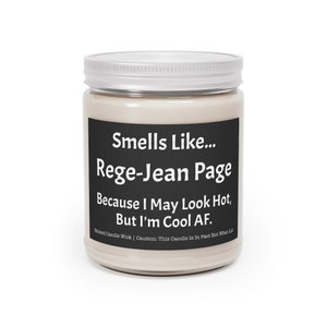 May include: A white candle jar with a black label that reads "Smells Like... Rege-Jean Page Because I May Look Hot, But I'm Cool AF."