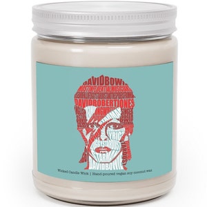 May include: A white candle jar with a blue and red label featuring a word cloud portrait of David Bowie. The label reads "Wicked Candle Wick | Hand-poured vegan soy coconut wax".